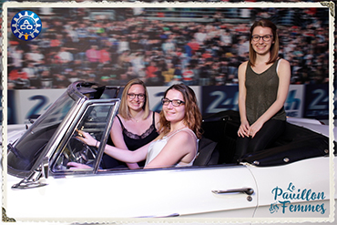 Photo prise par une borne photo de trois femmes assises dans une ancienne voiture au Pavillon des Femmes des 24 heures du Mans